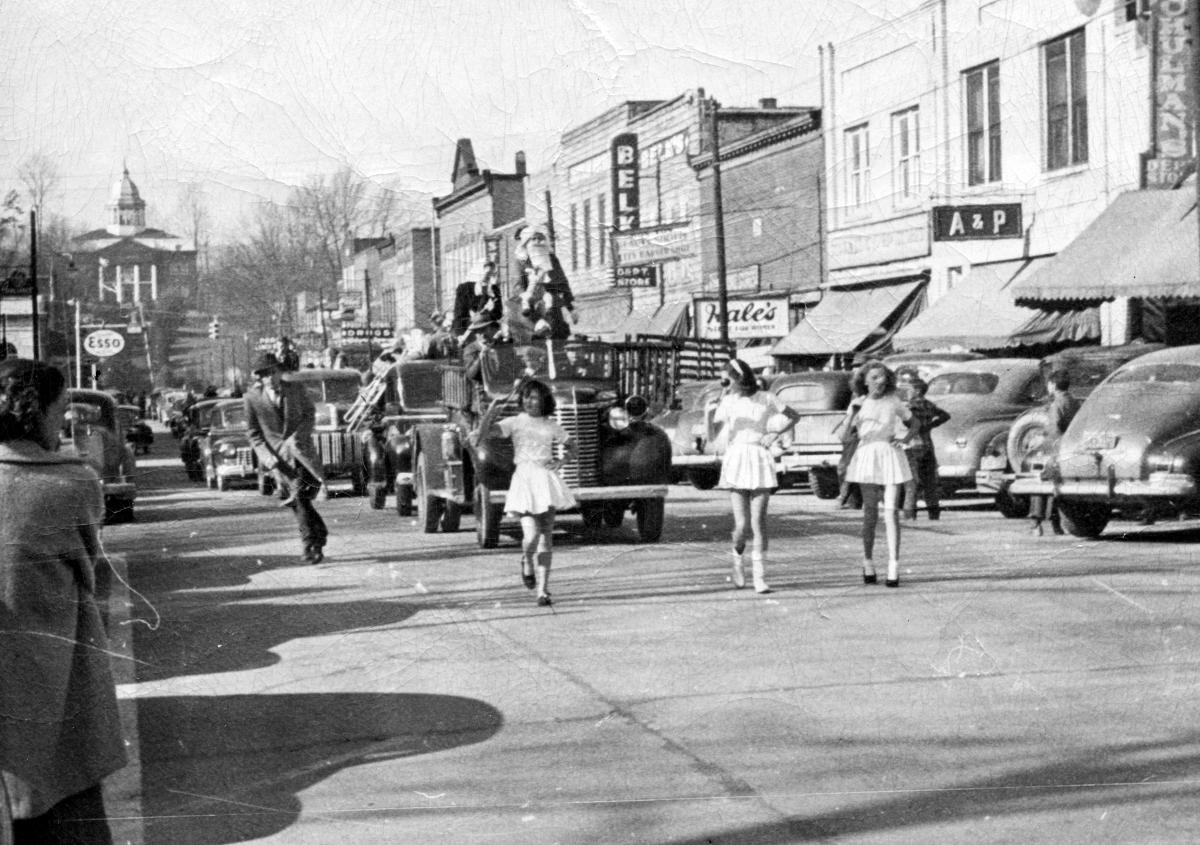 Majorettes and Santa Claus on a truck in a late-1940s Christmas parade on Main Street in Sylva, NC, past Belk, Hale’s and the A&P, with the courthouse behind