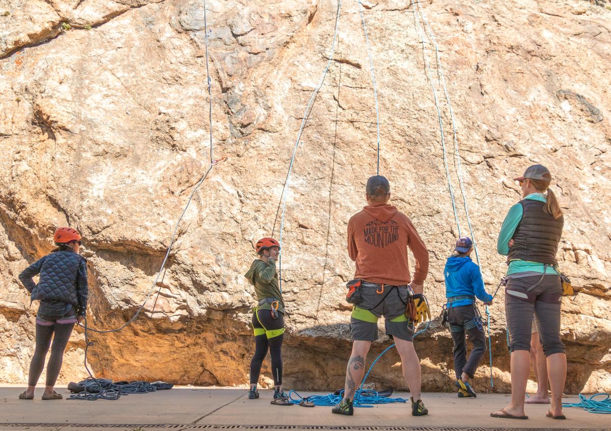 Five people at a rock wall climbing