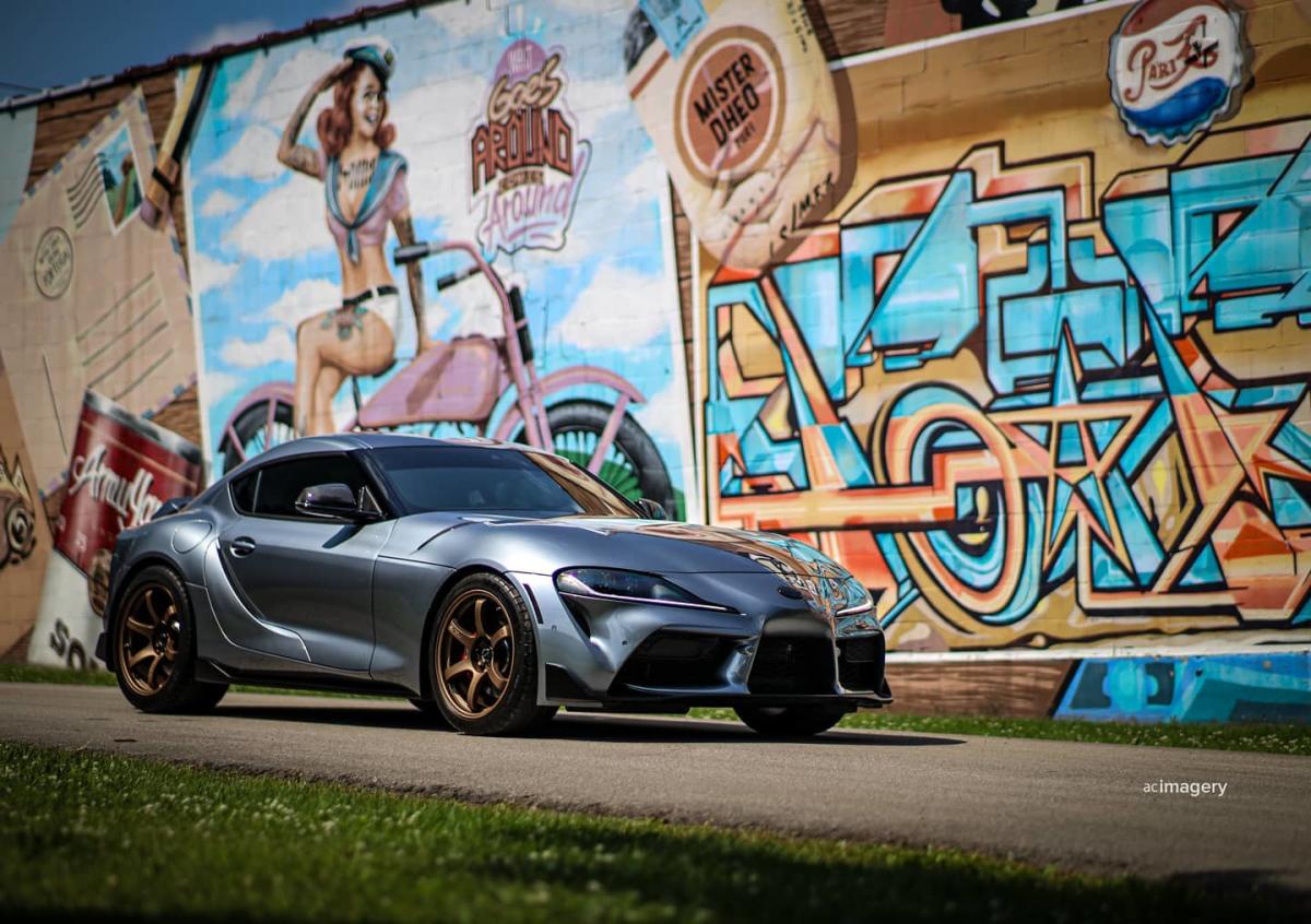Sports car parked in front of a mural