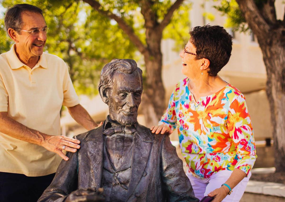 People posing with Abe Lincoln statue in the city of presidents in rapid city, sd
