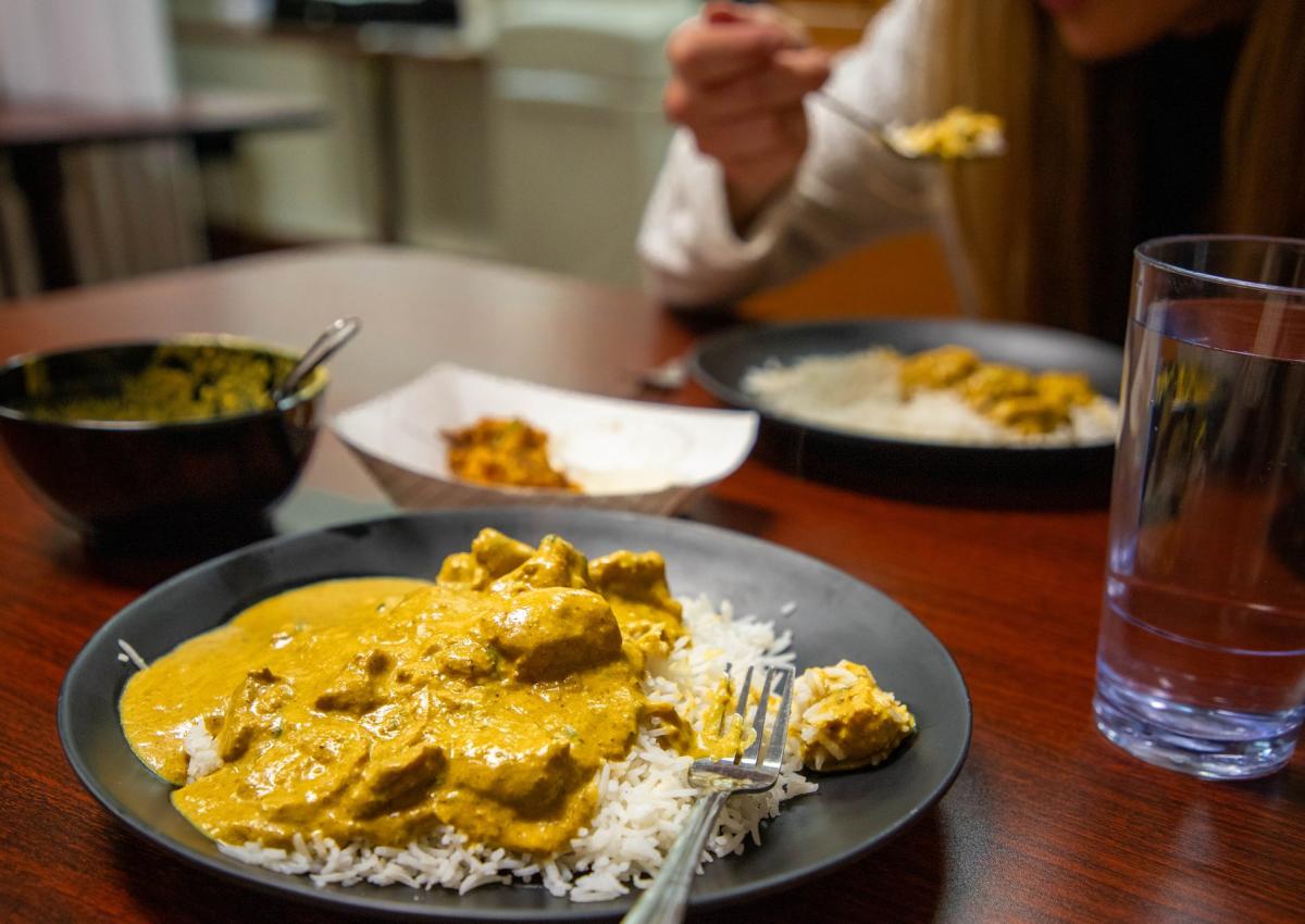 curry on rice with person eating in background at bengal kitchen in rapid city, sd