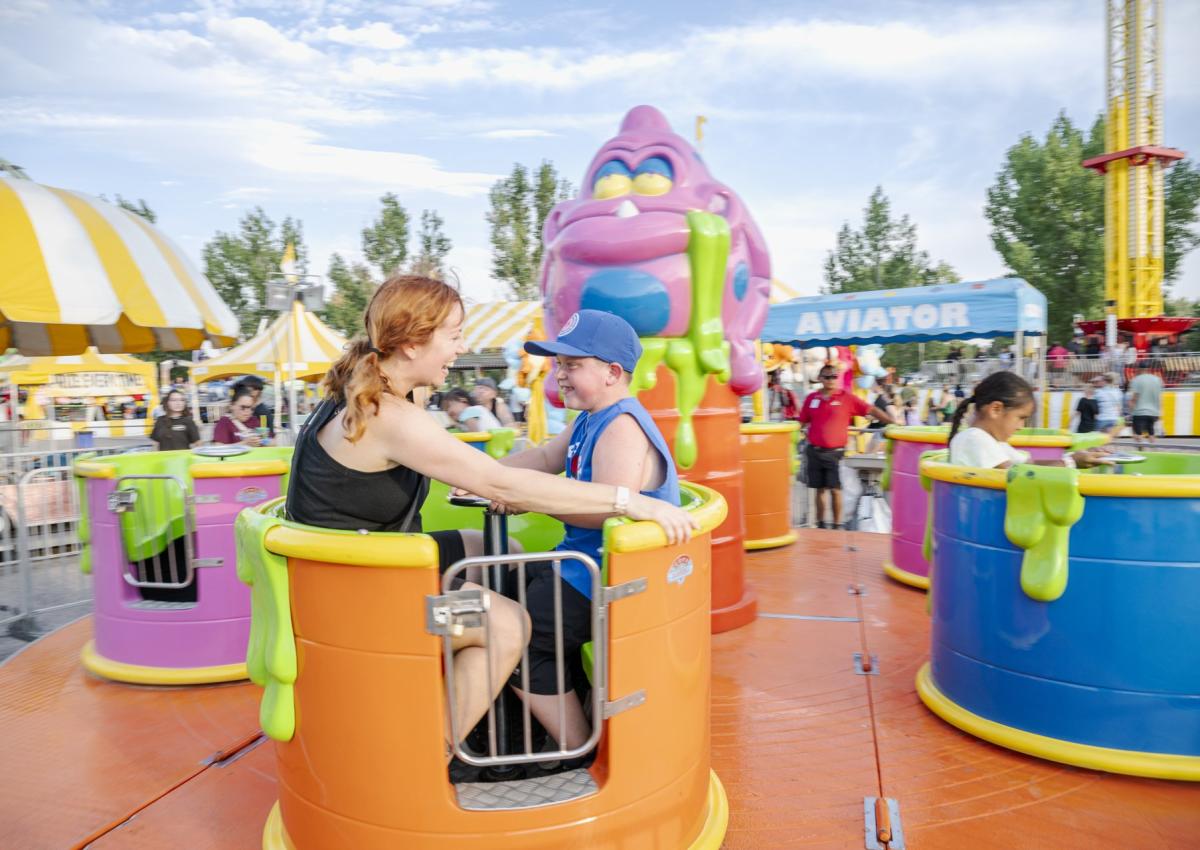 two people riding the spinning tea cups ride at the central states fair in rapid city