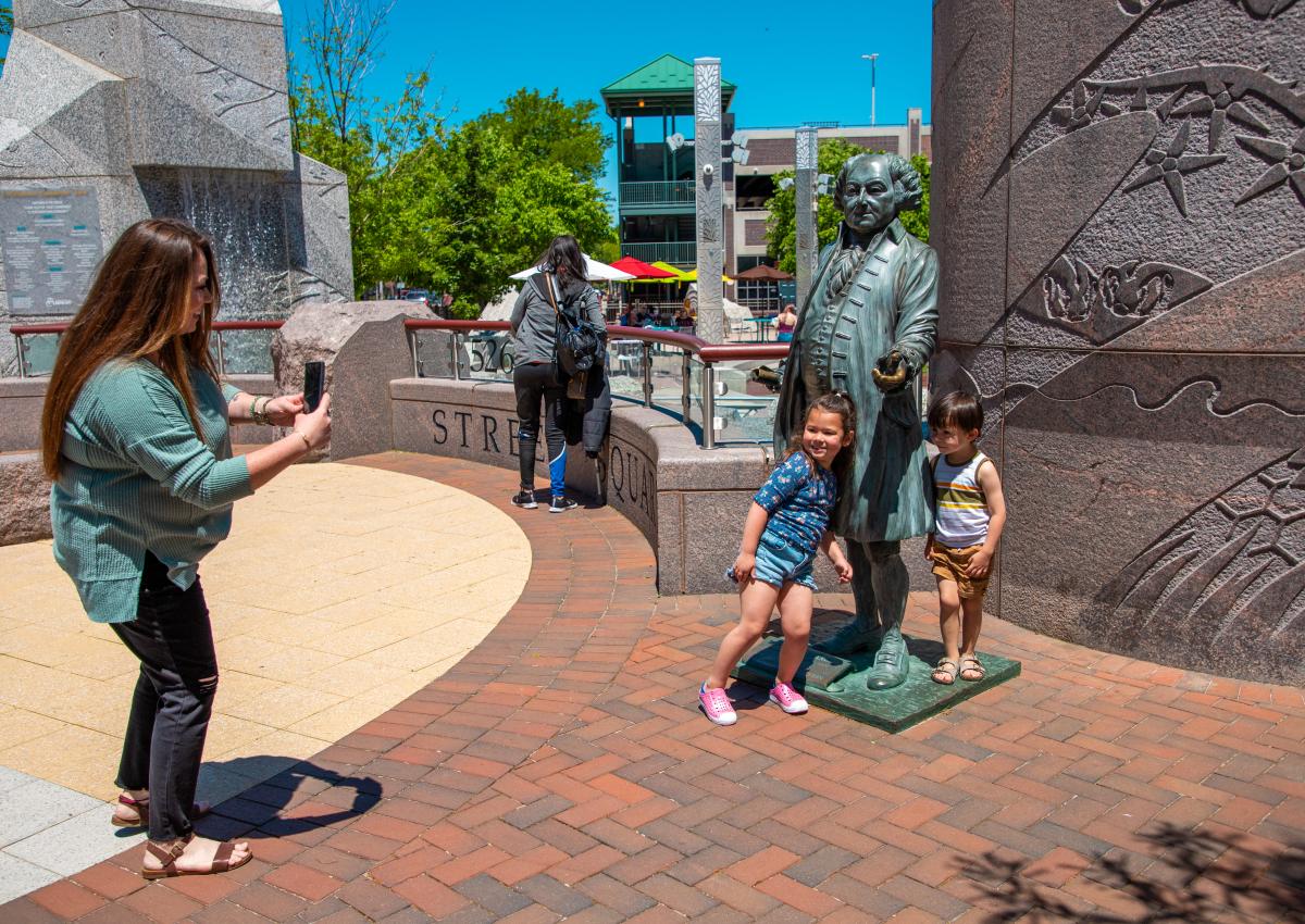 family posing around the John Adams statue in downtown rapid city, sd
