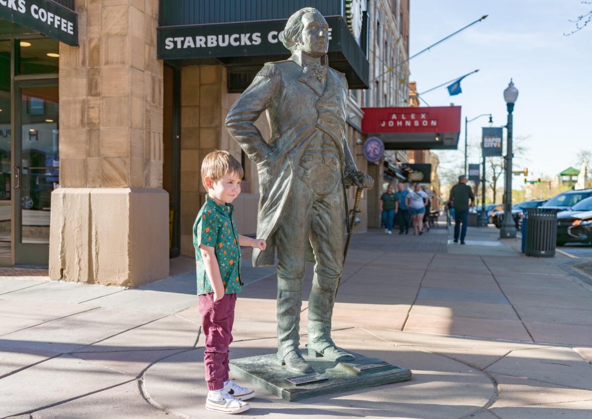 kid posing like george washington in downtown rapid city, sd