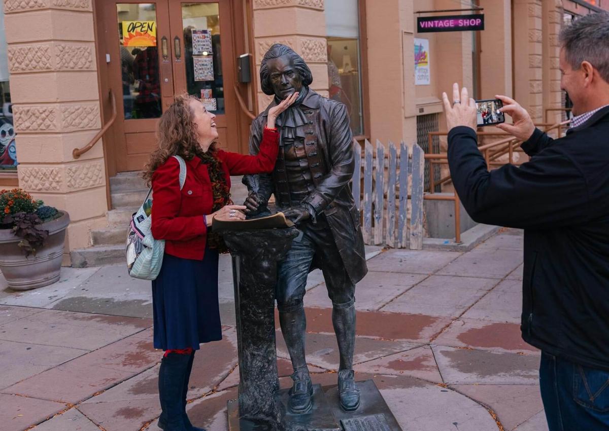 Couple posing with Thomas Jefferson's city of president statue in Rapid City, South Dakota