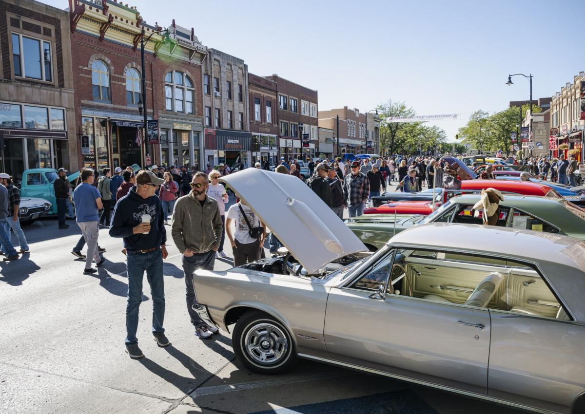 people walking the streets of downtown rapid city touring classic cars during the cruiser car show in rapid city,sd
