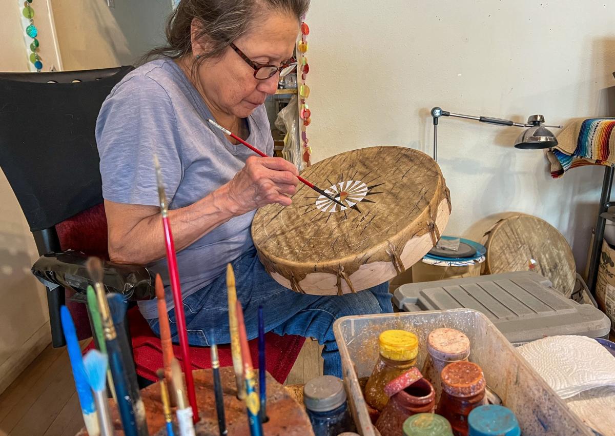 artist sonja holy eagle painting drums at dakota drum company in rapid city, sd