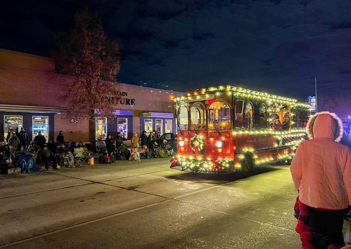 the city view trolley decorated in lights driving through Rapid City, SD in the festival of lights parade