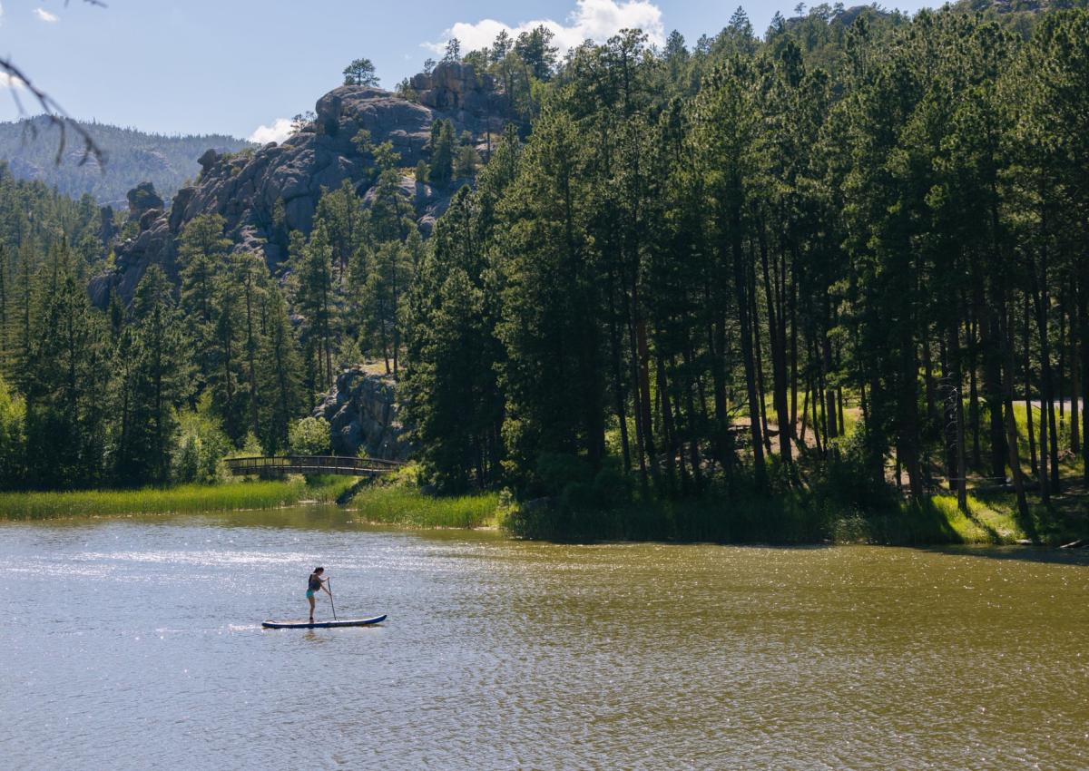 Paddle boarder on horsethief lake in the black hills national forest