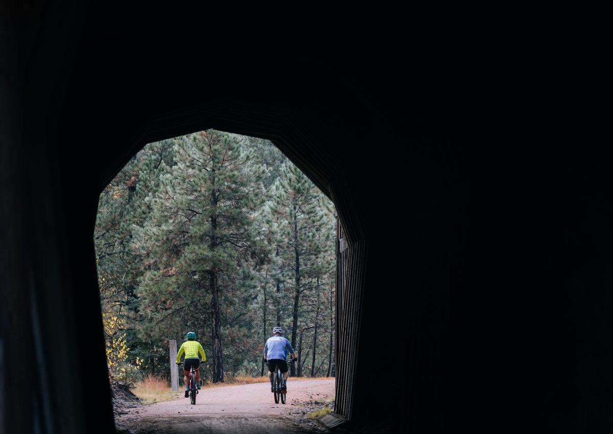 two bikers exiting one of the tunnels found along the rails to trails route of the george s mickelson trail in the black hills