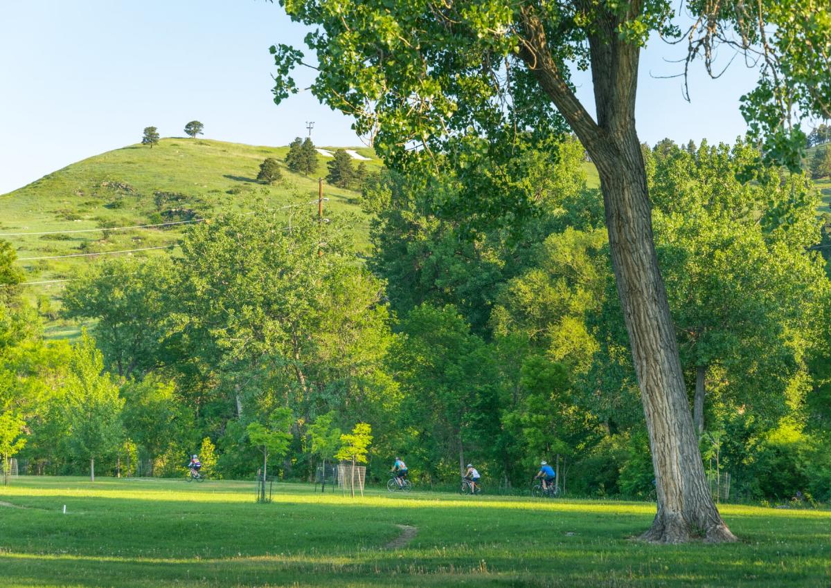 group of bikers riding the rapid city bike path through founders park in rapid city,sd