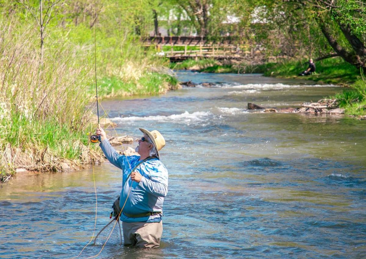 man fishing in the water of rapid creek in rapid city south dakota