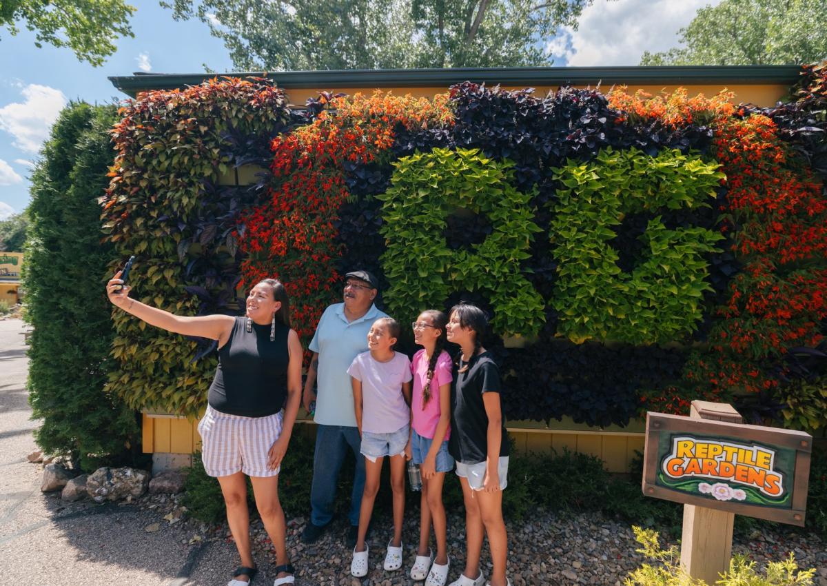 family posing in front of living flowers wall at reptile gardens in rapid city