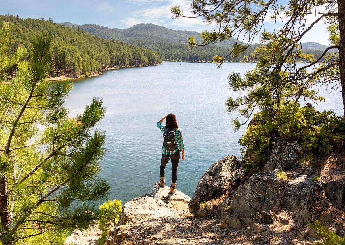 hiker enjoying the overlook from the centennial trail in south dakota at sheridan lake in the black hills