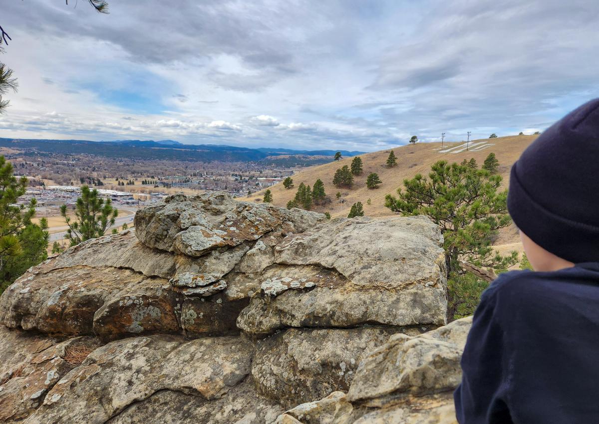 family overlooking the view of M hill and Rapid City, Sd from the trails of Hanson-larsen memorial park