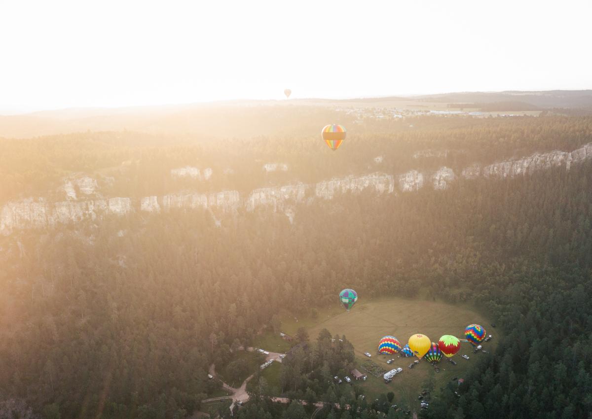 drone shot of hot air balloons taking off from the stratobowl near rapid city, sd