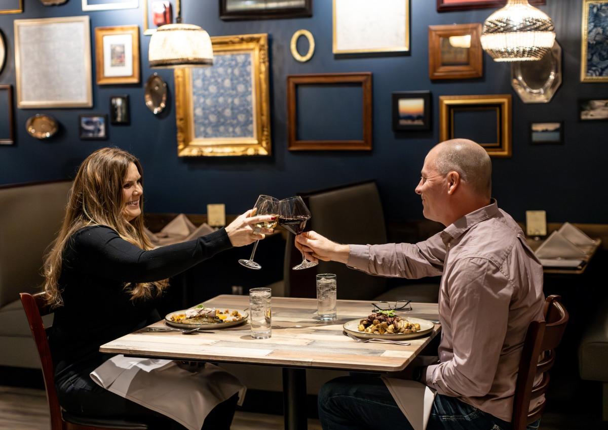 couple cheers-ing wine over a meal at tandoor bocado in downtown rapid city, sd