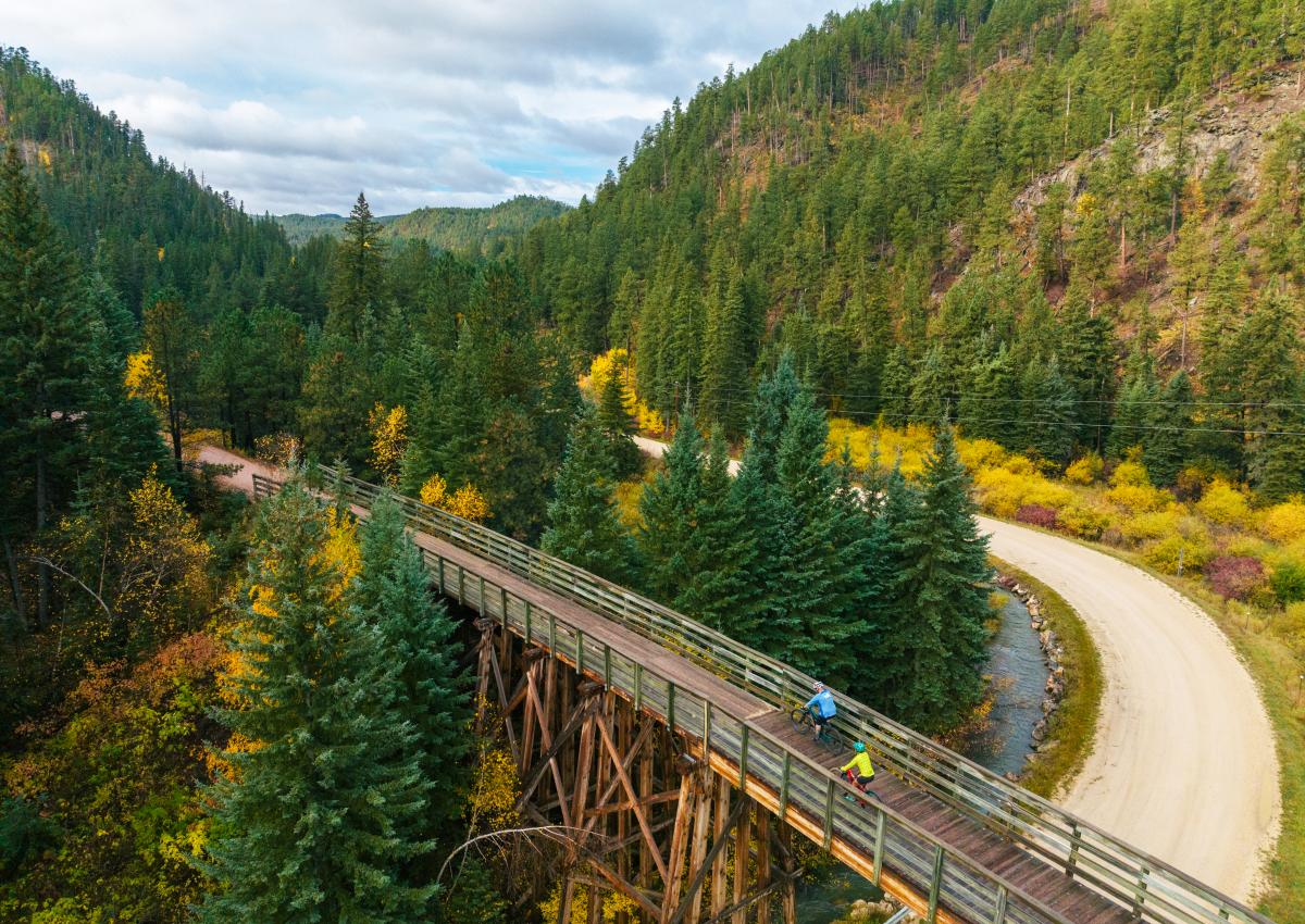 Two bikers riding Mickelson Trail in South Dakota during the fall