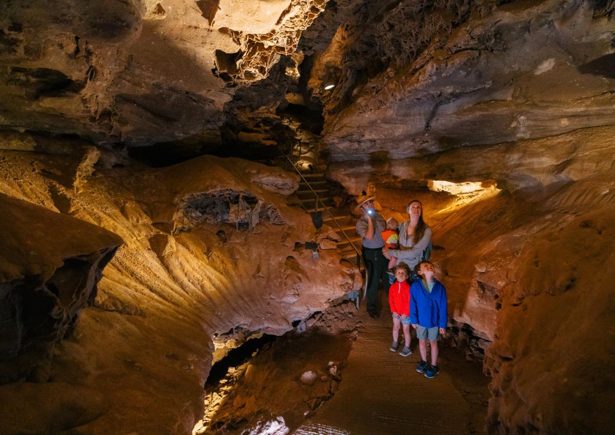 family with tour guide exploring the cave in wind cave national park