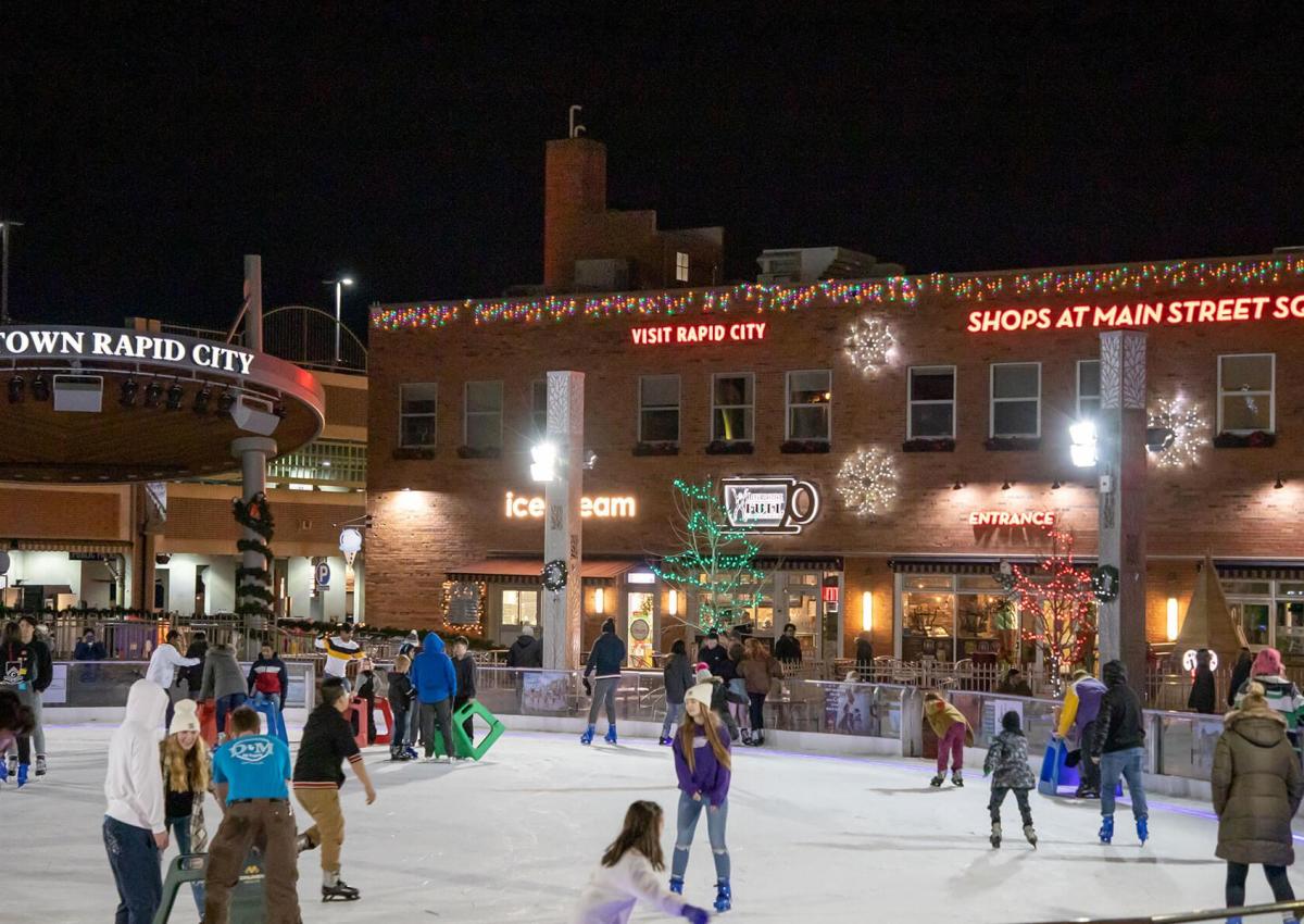People ice skating at night in Main Street Square the heart of Rapid City, SD