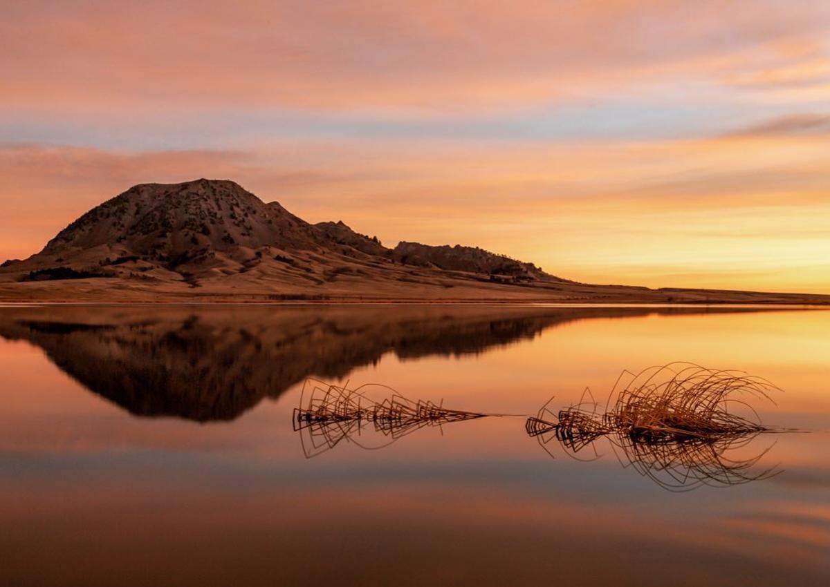 sunrise reflecting off the lake at bear butte state park in south dakota
