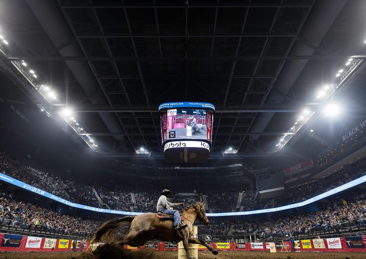 cowboy on a horse barrel riding with a crowd inside the summit arena in rapid city, SD