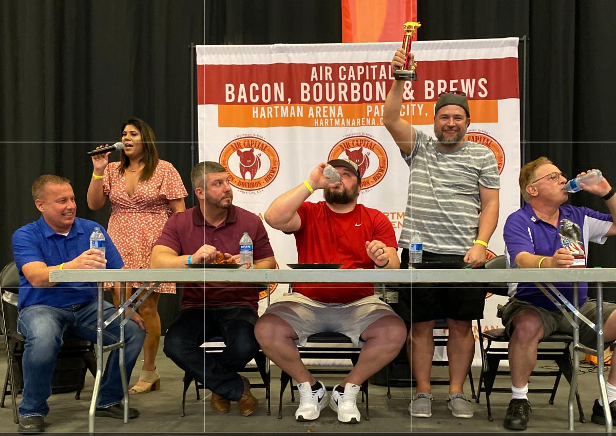 Men compete in the bacon-eating contest at the Air Capital Bacon, Bourbon and Brews Festival