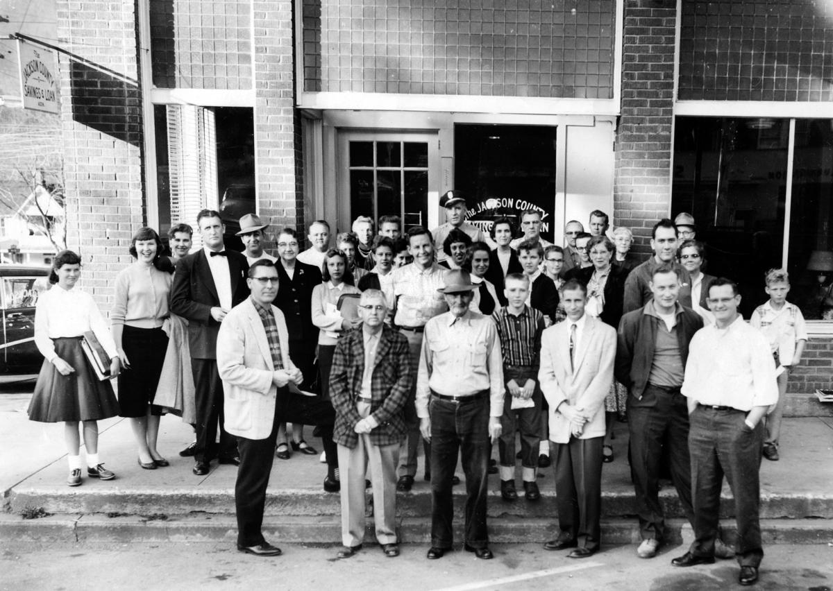 About 40 residents and a police officer posing in front of the new Jackson County Savings & Loan in the Hotel Lloyd building in Sylva, NC, around 1958