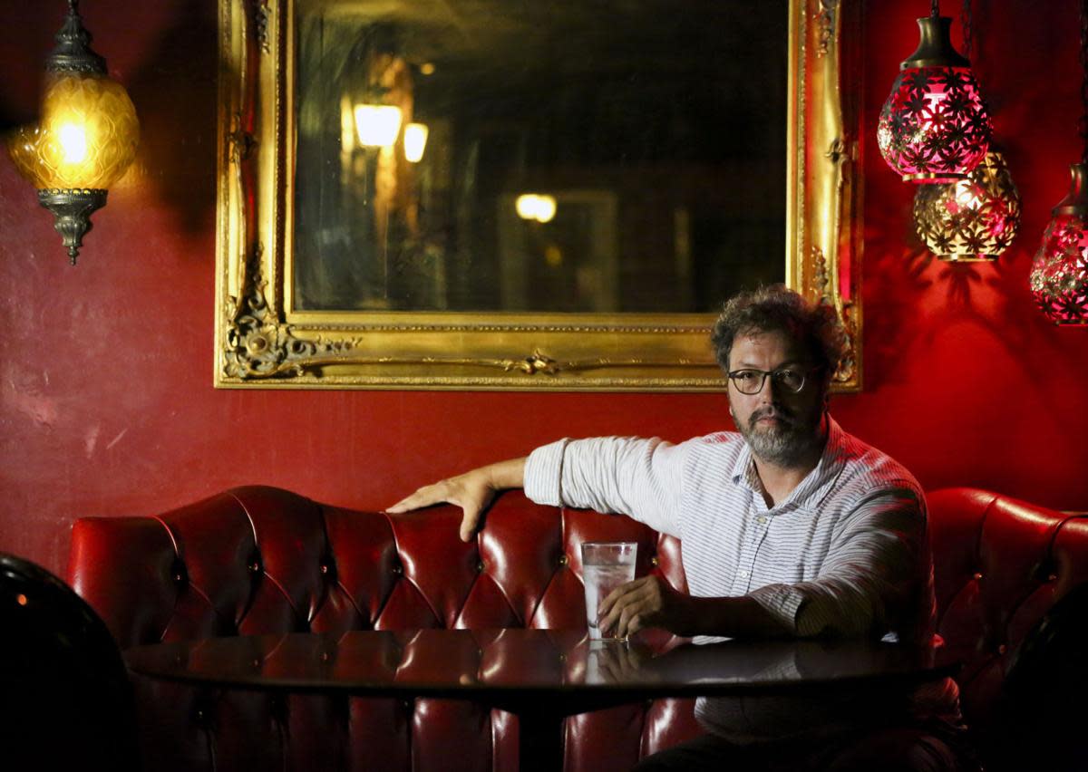 a man sitting in a booth at the cellar dweller