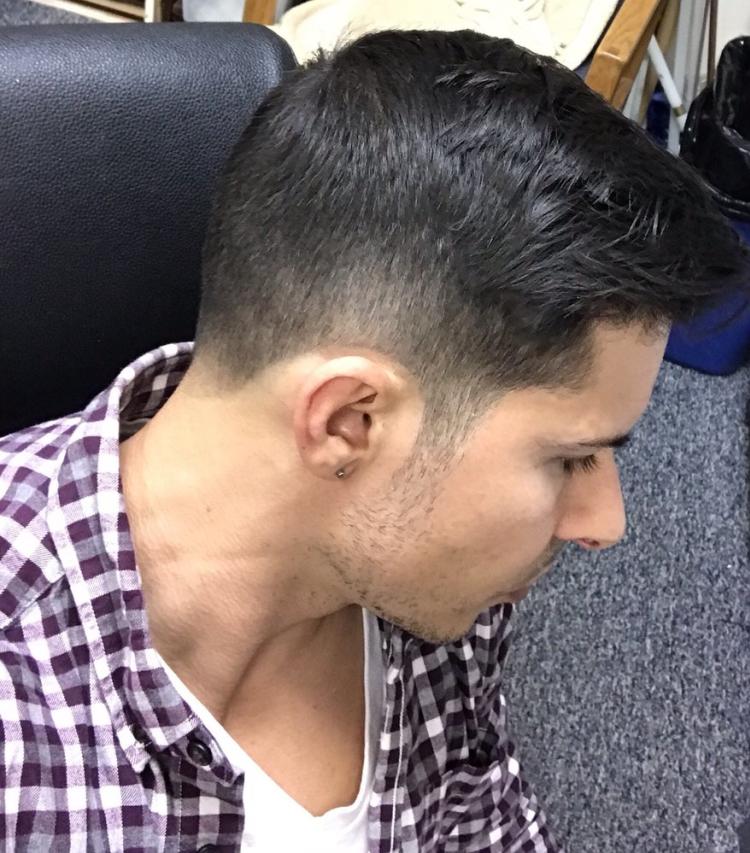 A young man with a freshly trimmed beard and styled hair