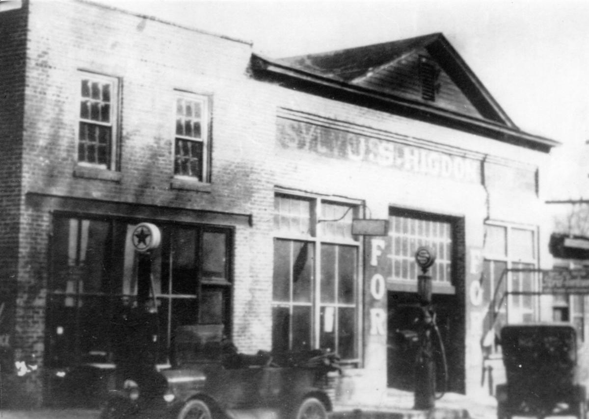 Early-1900s photo of J.S. Higdon’s Ford garage on Main Street in Sylva, NC, with Texaco and Standard gas pumps and Model T cars out front