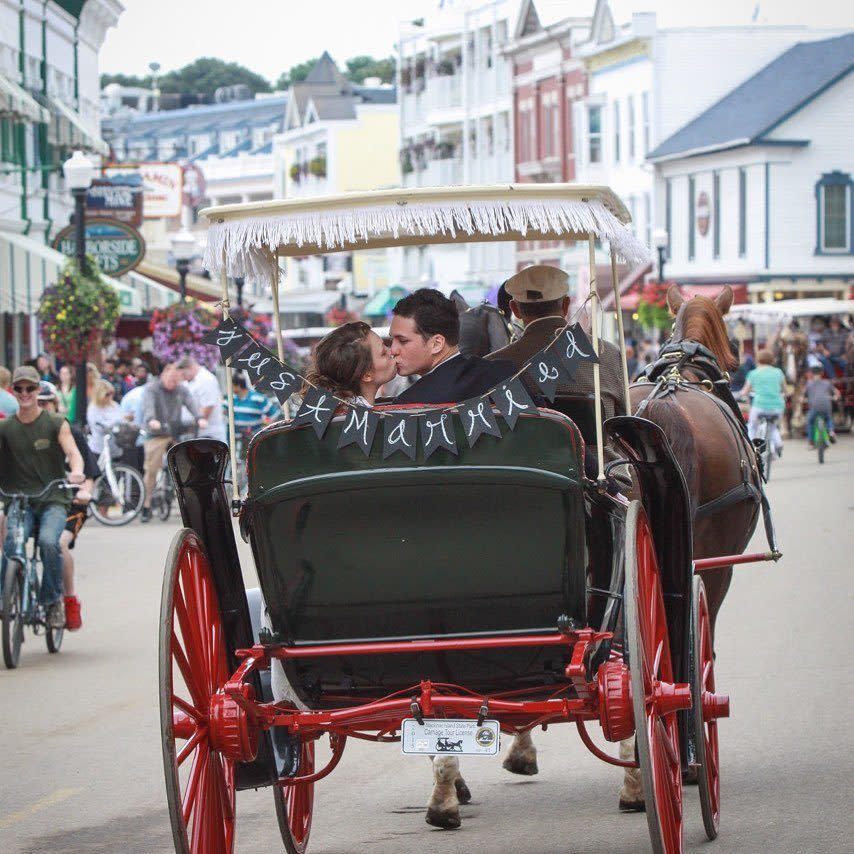 Newly-Wed Couple Kissing in Back of Horse-Drawn Carriage on Mackinac Island