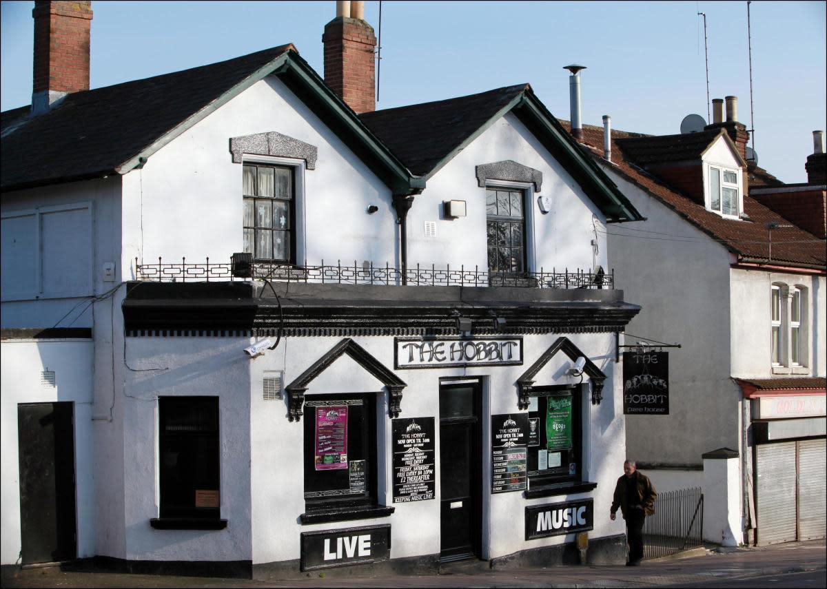 Exterior of The Hobbit pub with signs promoting live music