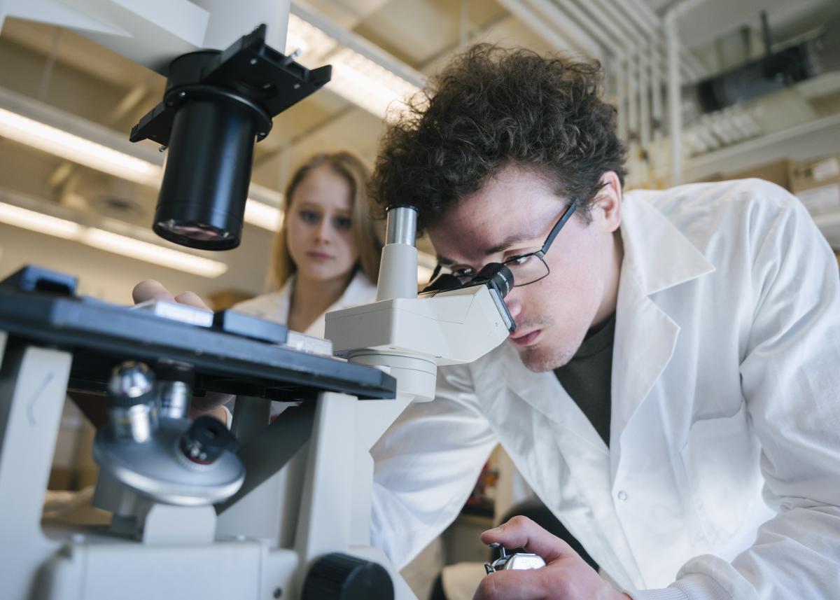 Student looking through Microscope UVM