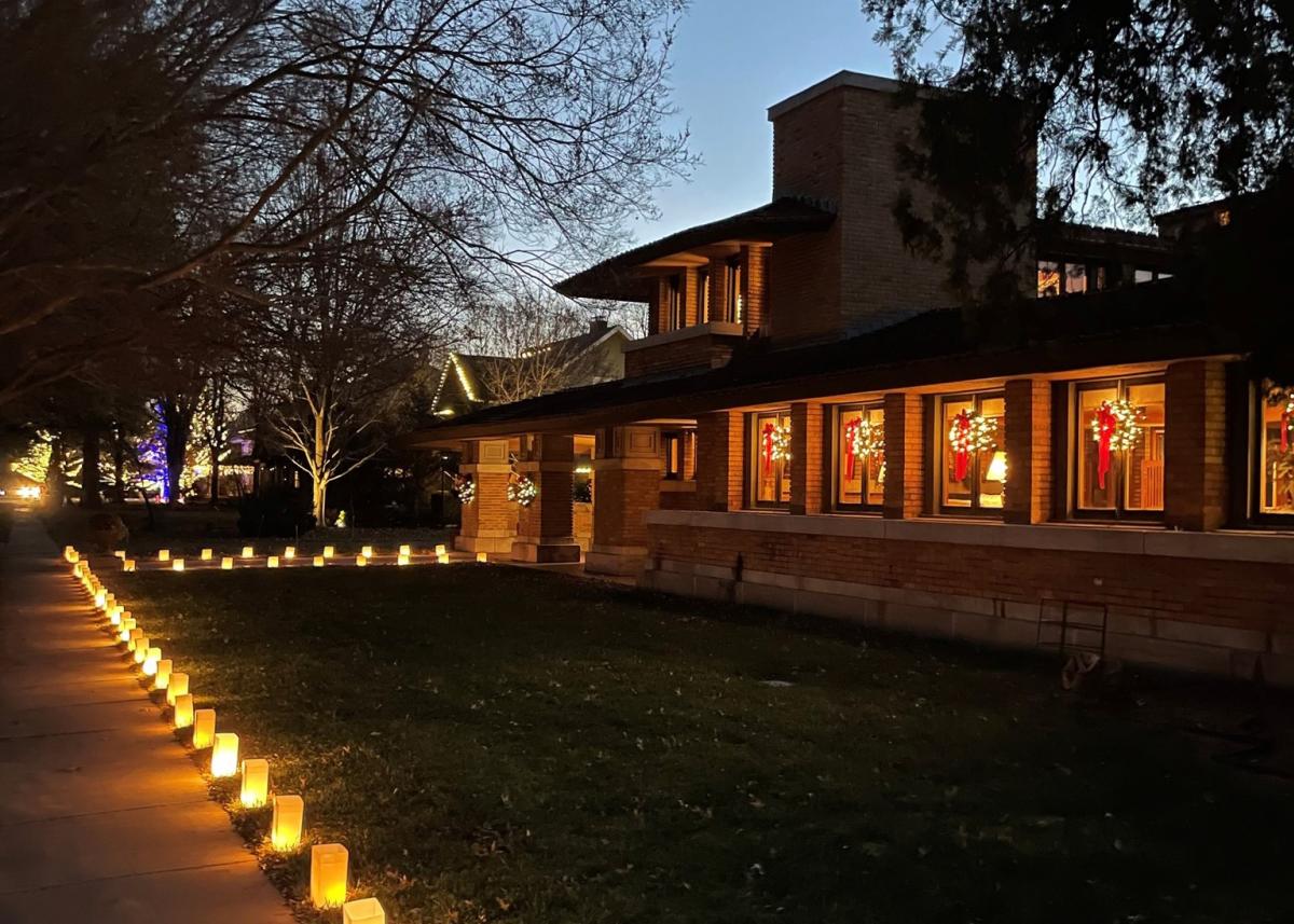 The Frank Lloyd Wright Allen House is decorated for the holidays with lit wreaths in the windows and lit bags lining the sidewalk.