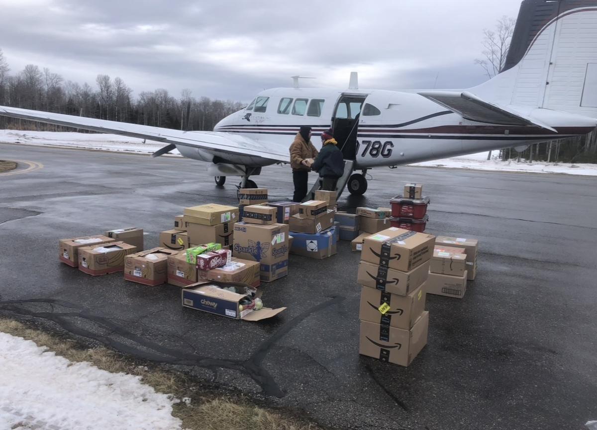 A plane on a snowy tarmac gets loaded with cargo for a flight to Mackinac Island