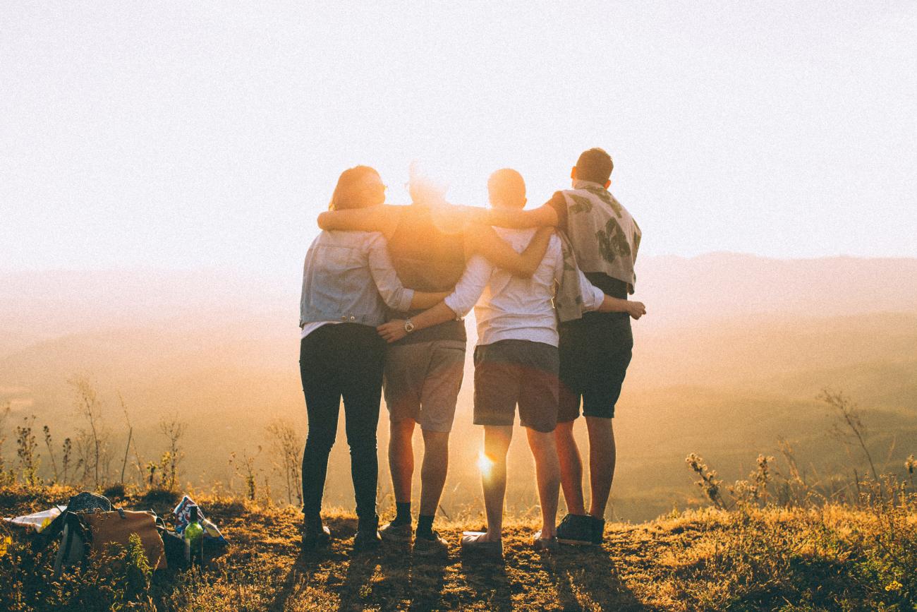 Group-friends-hugging-after-hiking-a-hill