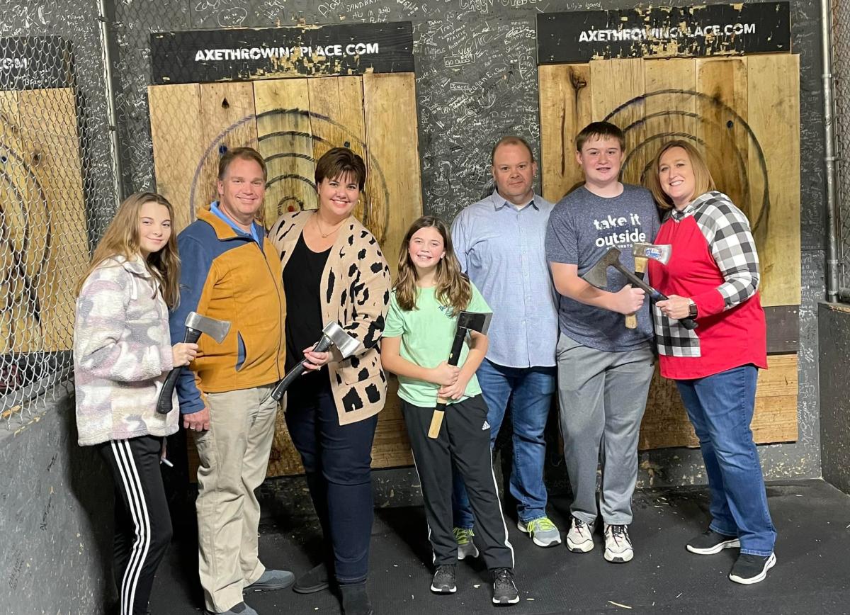 two families in an axe-throwing room