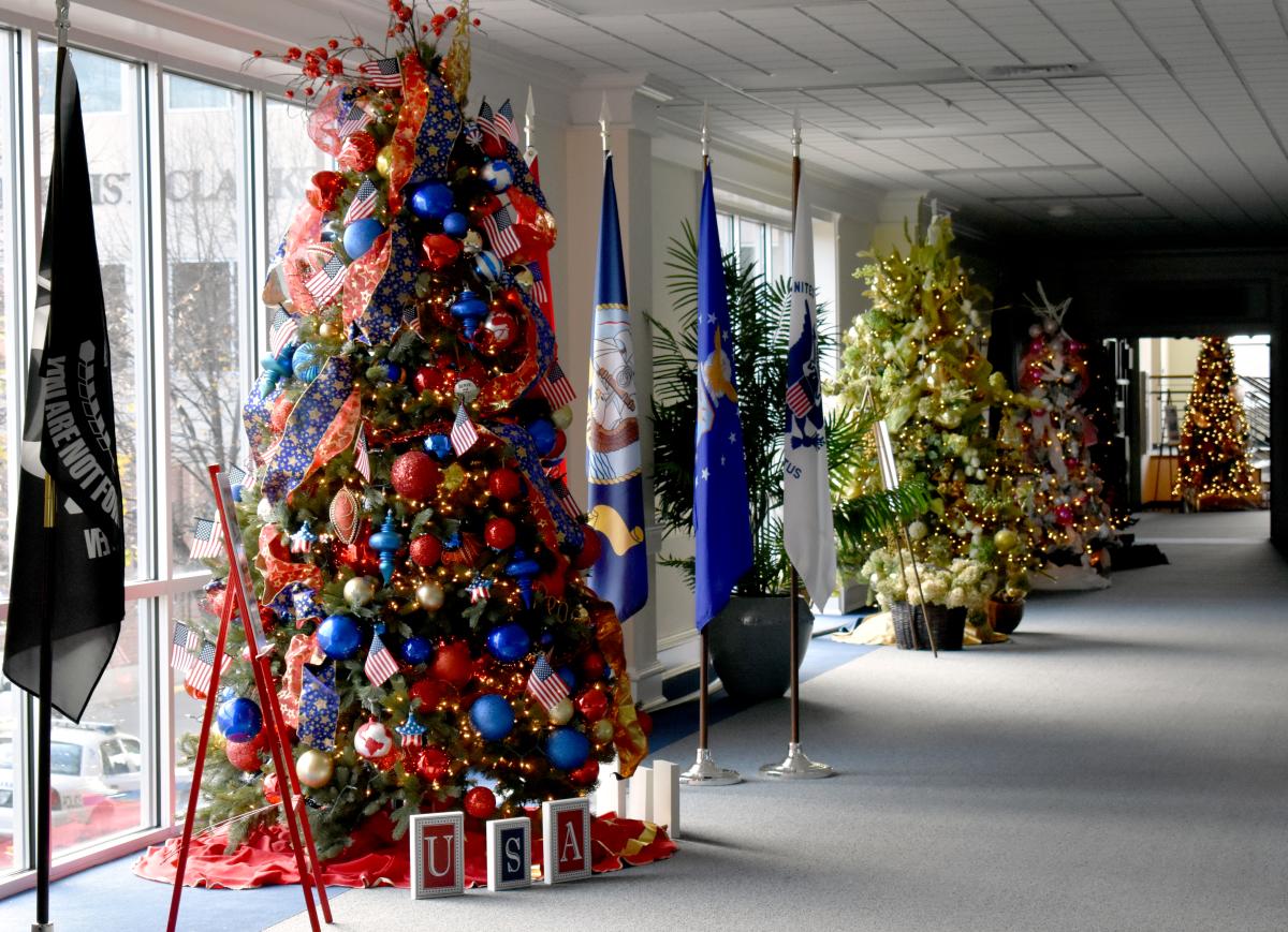 Decorated Christmas trees line the hallway.