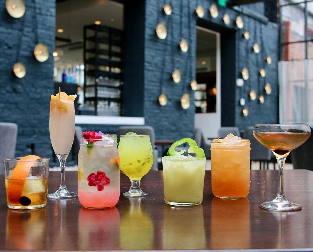 A row of various cocktails, colored pink, yellow, amber and green at Coppin's Restaurant in Covington, Ky.