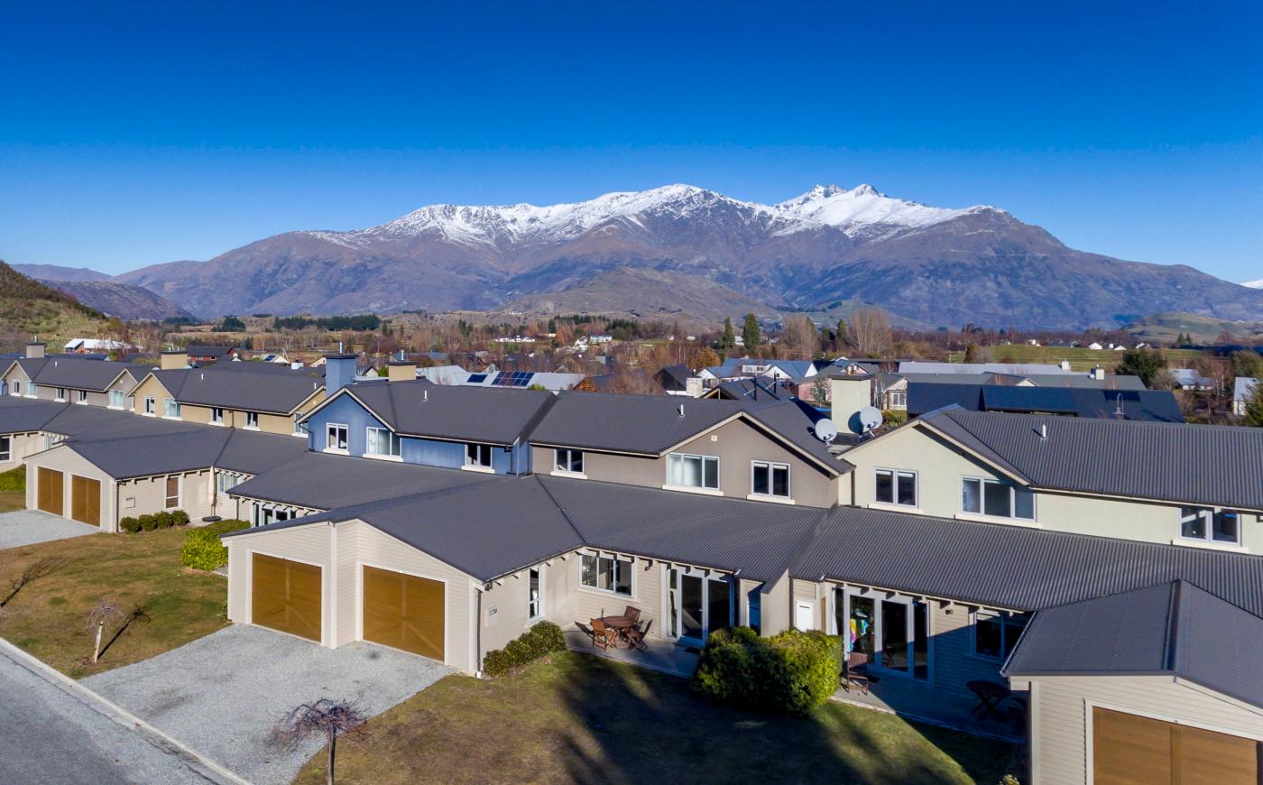 Aerial view of Arrowfield Apartments with snow-capped mountains in the background