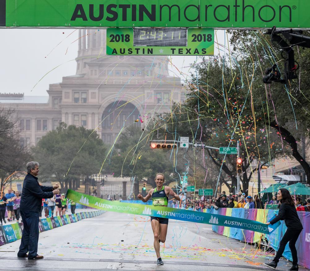 Runner crosses the finish line at the Austin Marathon in austin texas