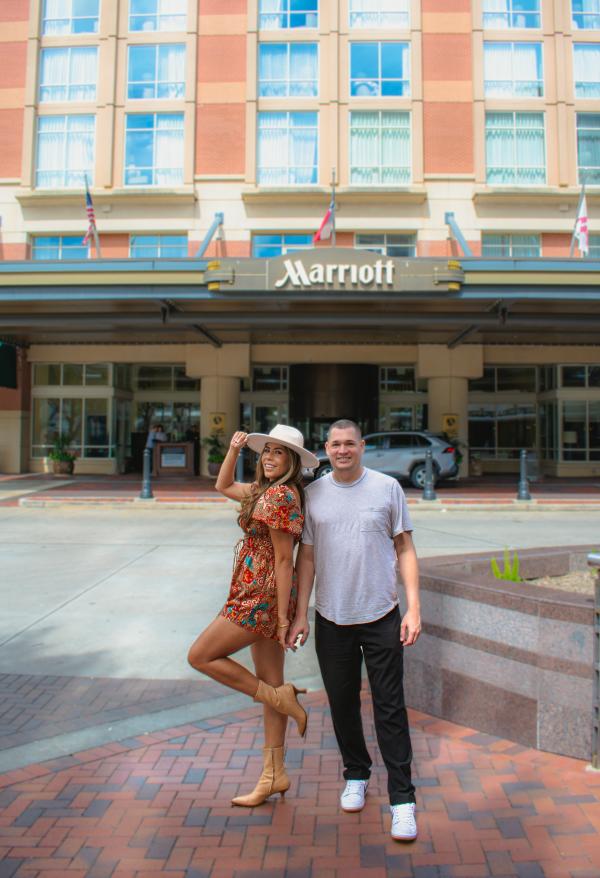 A couple standing in front of the Houston Marriott Sugar Land