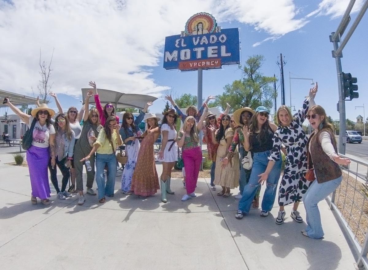 A group of influencers pose in front of the El Vado Motel sign