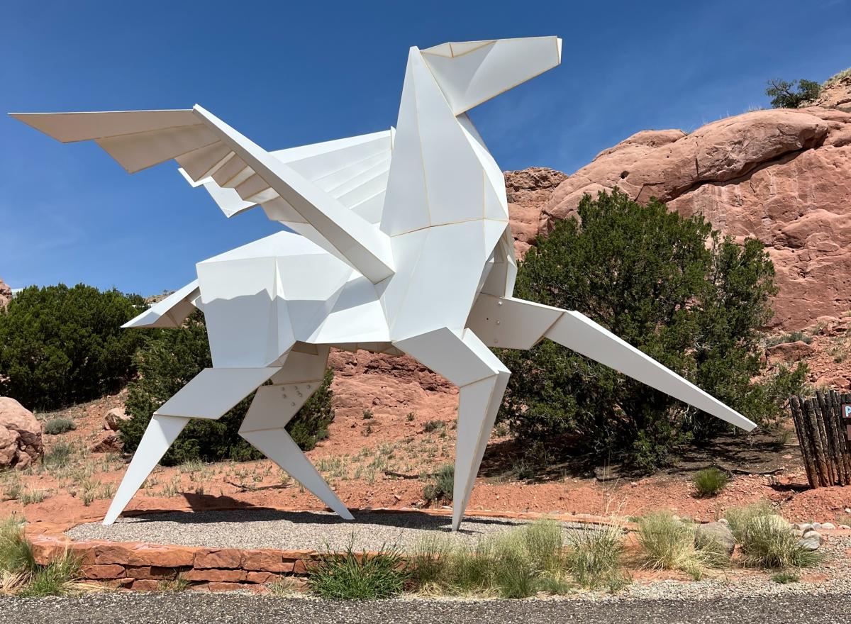 A photo of a sculpture at Origami in the Garden. The sculpture is a white horse with wings.