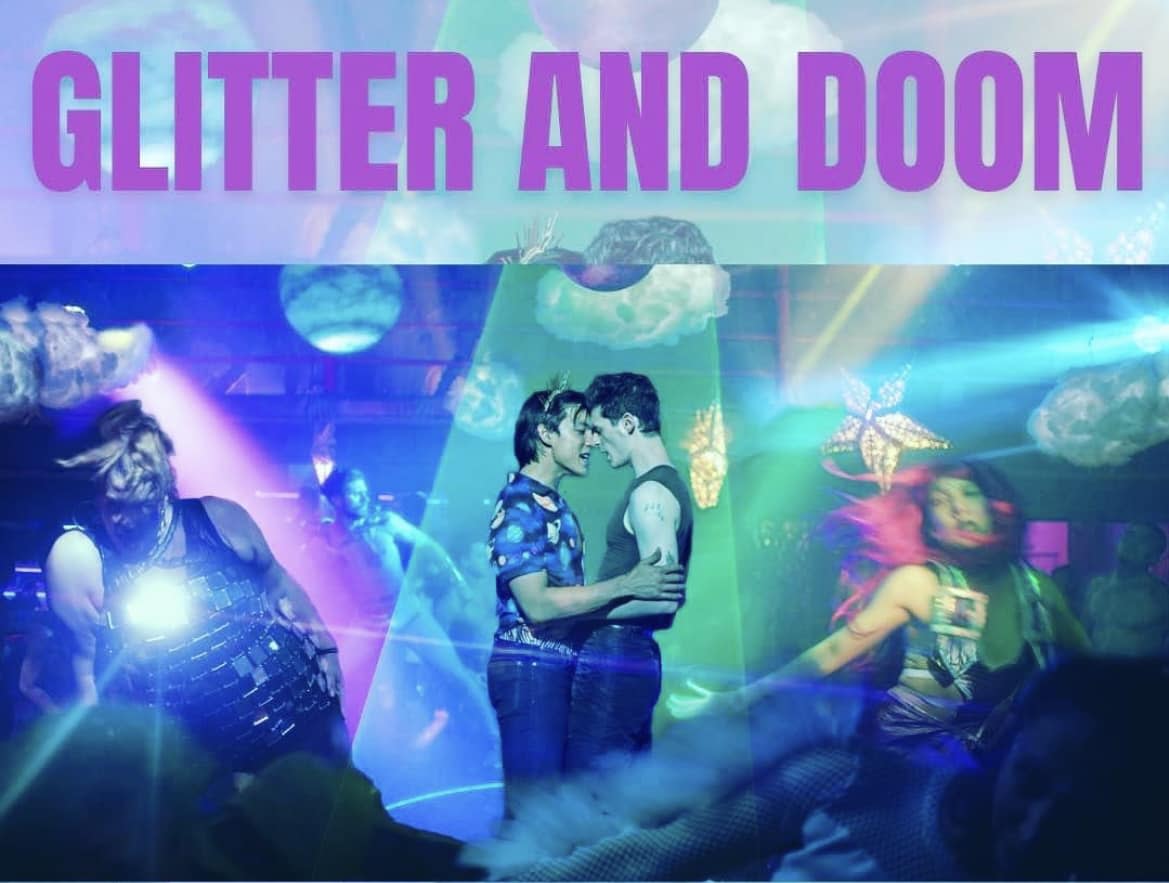 Movie poster in teal, sea green, and purple with two men embracing in the center. Text reads Glitter and Doom.