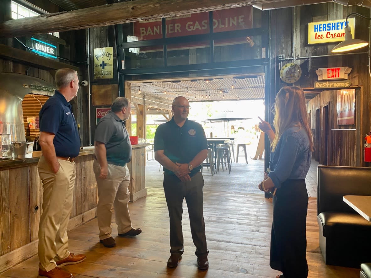Assemblymen speak with Three Brothers owner inside Bagg Dare, a rustic bayou styled bar