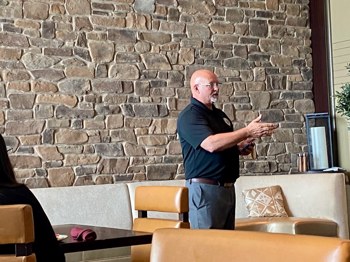 Jeff Gallahan standing in front of a room with slate stone wall behind him