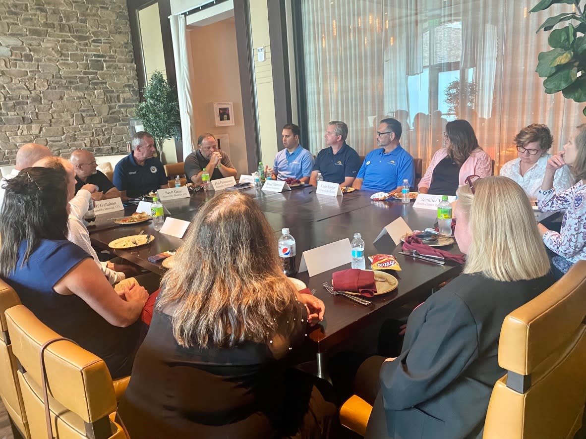 Group of people sit in a circle around a table to have a discussion while finishing lunch