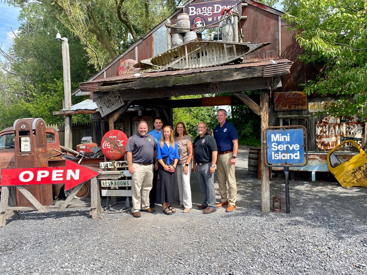 Group of people standing together outside of a rundown styled bar entrance